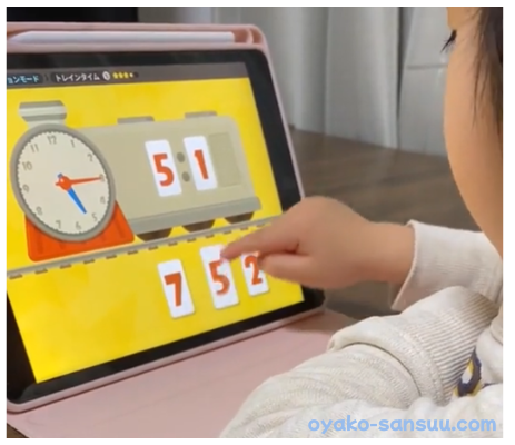 トドさんすうで3歳児が時計を見て時間を学んでいる画像